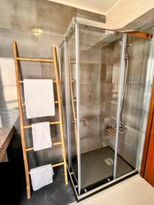 a shower with a glass door and towels at Stay In Madeira in Funchal