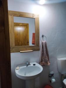 a bathroom with a white sink and a mirror at Departamentos Sato in Apóstoles