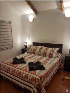 Un dormitorio con una cama con dos sombreros. en cabañas Honu iti, en Hanga Roa