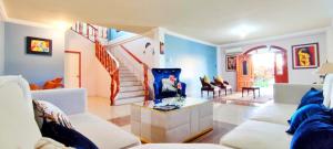 a living room with white furniture and a staircase at Bahía Gardner in Puerto Baquerizo Moreno