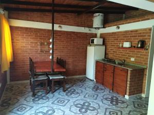 Guerrero في San Roque: مطبخ مع طاولة خشبية وجدار من الطوب