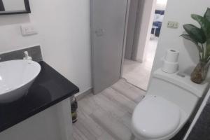 a bathroom with a white toilet and a sink at Casa de las Mariposas in Río San Juan