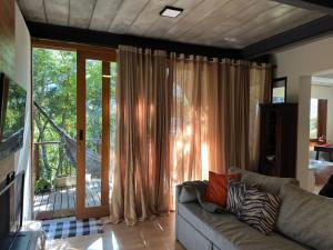 a living room with a couch and a large window at O Chalé mais bucólico de Araras. Vista linda in Petrópolis