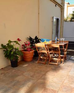 uma mesa de madeira e cadeiras num quarto com plantas em Just Chill Villa em Trou-aux-Biches