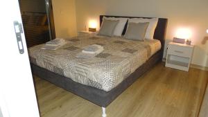 a bedroom with a large bed and a wooden floor at Casa Bocage in Verdelho