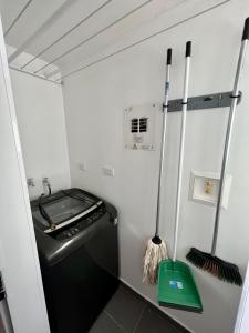 una pequeña cocina con lavadora y escoba en Apartamento mínimo por 30 dias, 2 Habitaciones, Sotomayor Bucaramanga, en Bucaramanga