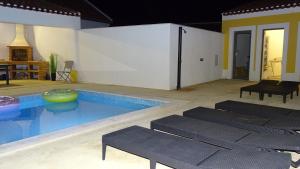 Casa Bocage في Verdelho: مسبح كبير مع كراسي في الغرفة