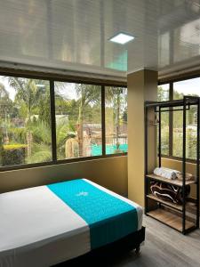 una camera da letto con un letto e una grande finestra di Hotel Campo Real a Rionegro