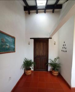 un pasillo con dos macetas y una puerta de madera en Finca villa Claudia a 25 min de villa de Leyva, en Villa de Leyva