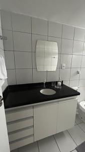 um banheiro com pia e espelho em lindo apartamento de frente para à praia de pajuçara em Maceió