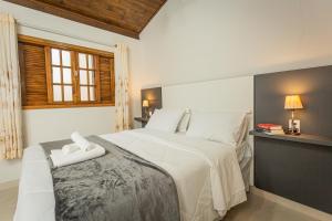 a bedroom with a bed with two towels on it at Chalé Mantiqueira - Cunha in Cunha