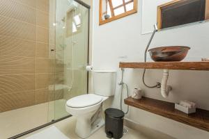 a bathroom with a toilet and a glass shower at Chalé Mantiqueira - Cunha in Cunha +30 photos