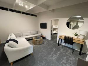 a living room with a couch and a table and a mirror at Private Water Front House in Whangaparaoa