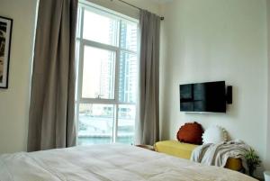 a bedroom with a bed and a large window at Amazing View I 1min Walk to Marina Mall I Close to Beach in Dubai