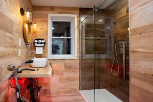 a bathroom with a shower and a red bike in it at Chalet Memphrémagog (Spa, étang, golf) in Mansonville