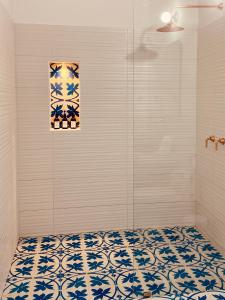 uma casa de banho com um chuveiro com azulejos azuis e brancos em Casa Santo Domingo Guadalupe Santander em Guadalupe