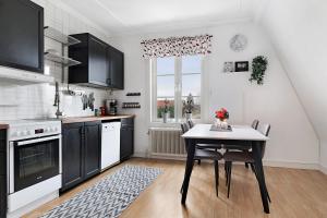 cocina con mesa, mesa y sillas en Guestly Homes - 4BR Charming Apartment, en Piteå