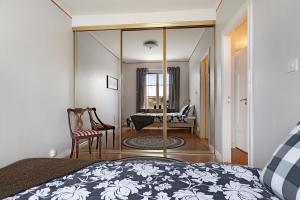 1 dormitorio con cama y espejo en Guestly Homes - 4BR Charming Apartment, en Piteå