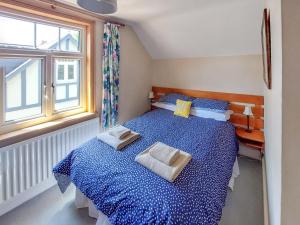 a bedroom with a blue bed with two pillows on it at Framingham in South Hayling
