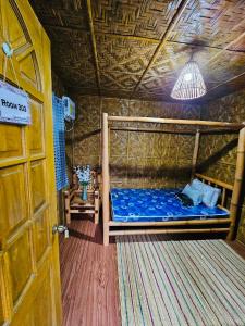 - une chambre avec un lit dans une pièce dotée d'un plafond dans l'établissement Ezekiel's Native Inn, à Panglao