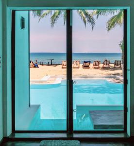 a view of the beach from the window of a house at Swisscocobeach in Nosy Be