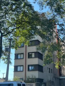 un edificio alto y blanco con ventanas laterales. en Lindo apartamento, en Curitiba