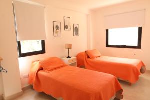 馬德普拉塔的住宿－Mar del Plata Acantilados vista al Mar，配有橙色床单的客房内的两张床