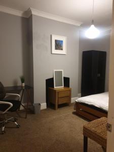 a bedroom with a bed and a desk and a chair at Derby rooms by Peartree in Derby
