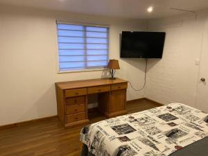 - une chambre avec un lit, un bureau et une télévision dans l'établissement Lindo Apartamento, full equipado -Factura empresas-, à Quillota