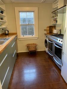 a kitchen with a stove and a dishwasher at Heritage Hideaway in Oamaru