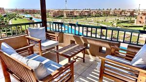 艾因蘇赫納的住宿－Chalet Marina Wadi Degla Families Only Pool view 2nd floor 6 adults，阳台配有桌椅,享有城市美景。