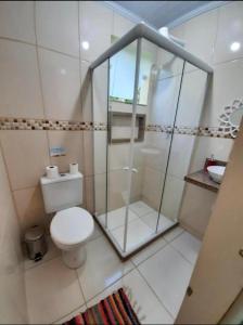 a bathroom with a toilet and a glass shower at Descanso do Jordão in Abraão