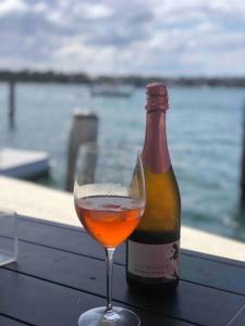 a bottle of wine sitting next to a glass at Sydney Harbourfront Boathouse and Studio Escape in Sydney