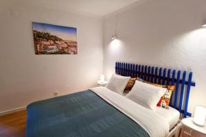 een slaapkamer met een groot bed met een blauw hoofdeinde bij Mouraria Lisbon Soul Apartments T2 - 5pax in Lissabon