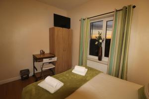 Schlafzimmer mit einem Bett, einem Schreibtisch und einem Fenster in der Unterkunft Middlecroft House in Staveley