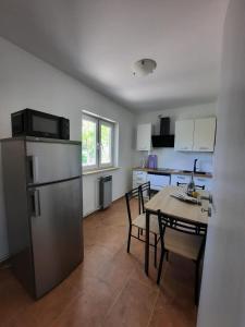 een keuken met een tafel en een koelkast bij Appartements Lena. in Premantura