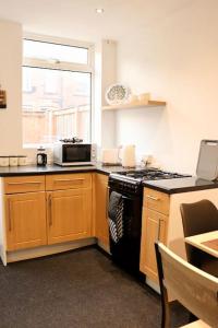 een keuken met een fornuis en een raam bij Charming 3 Bedroom Property FREE WiFi & Parking in Beeston