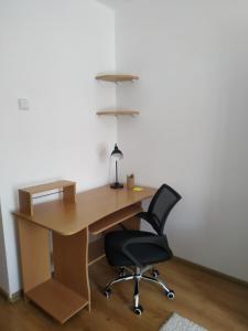 an office with a wooden desk and a black chair at príjemné ubytovanie in Košice