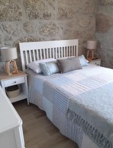 a bedroom with a white bed with two night stands at Villa Dos Santos - Gerês Country House in Geres