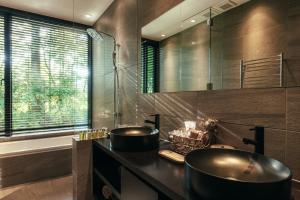 a bathroom with two sinks and a tub at La Maison Karuizawa in Karuizawa