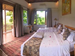 a bedroom with two beds and a balcony at Bangsring Breeze in Banyuwangi