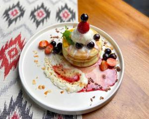 a plate of food with a pastry with fruit on it at Dewa Hostel in Ubud