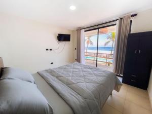 a bedroom with a bed and a view of the ocean at REEF ON THE WATER in Tamanique