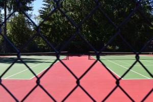 a view of a tennis court through a net at Judys Island Getaway179 in Shelton