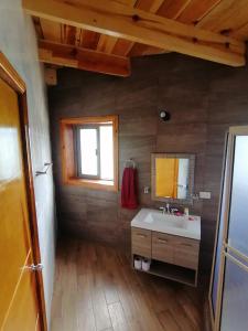 La salle de bains est pourvue d'un lavabo, d'un miroir et d'une fenêtre. dans l'établissement Cabaña los peñascos, à Creel