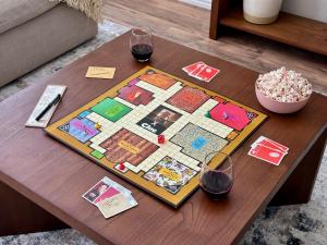a table with two glasses of wine and a board game at Modern Home Close to It All in DFW Texas! in Grand Prairie