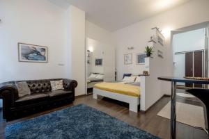 a bedroom with a bed and a couch and a table at Stylish Downtown Studio in Budapest