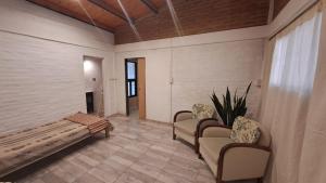 a living room with chairs and a bench and a plant at Rest Home Los Horneros in Santa Ana