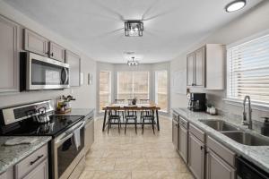 a kitchen with white cabinets and a table with chairs at Modern Home Close to It All in DFW Texas! in Grand Prairie