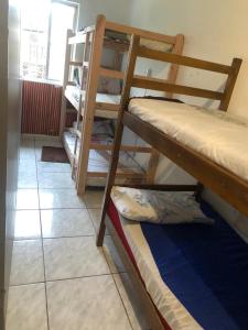 een kamer met 2 stapelbedden en een raam bij Hostel Celine in São Bernardo do Campo